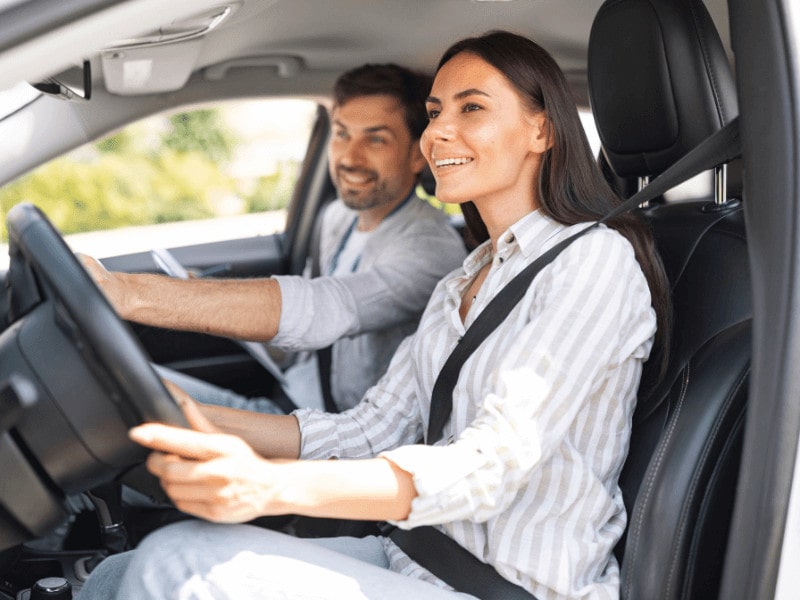 Profesor de autoescuela con su alumna al volante